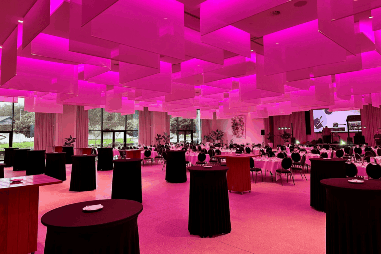 Zaal Andromeda in De Montil, feestelijk verlicht in roze tinten.