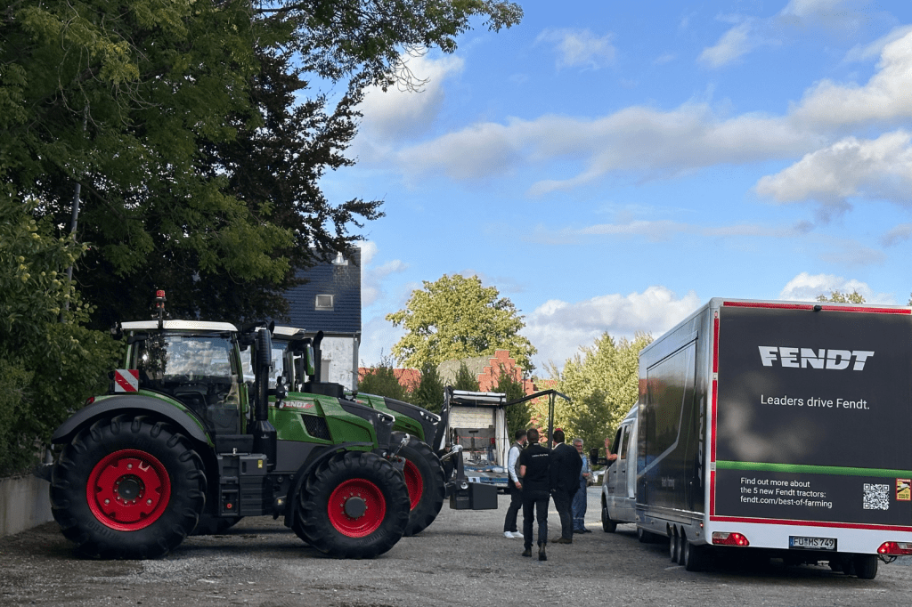 Tractoren en promowagen buiten bij de locatie tijdens de opbouw van een lanceringsevent