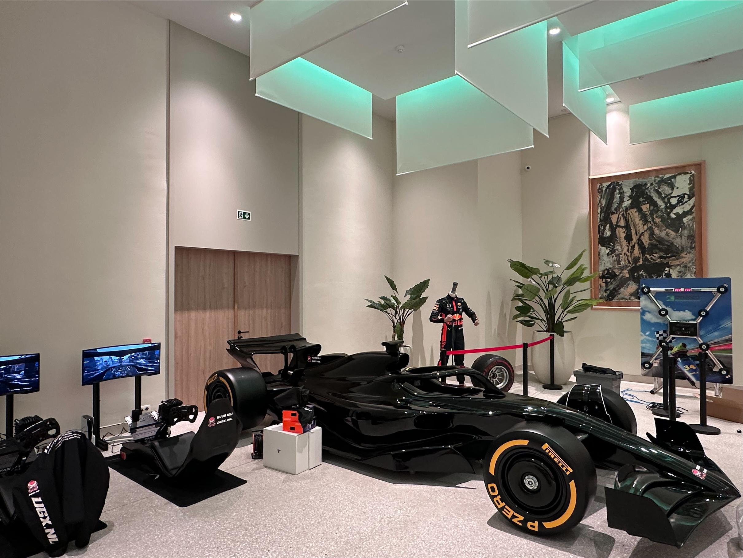 Moderne eventruimte met Formule 1-simulator en racewagen als originele activiteit voor een bedrijfsfeest.
